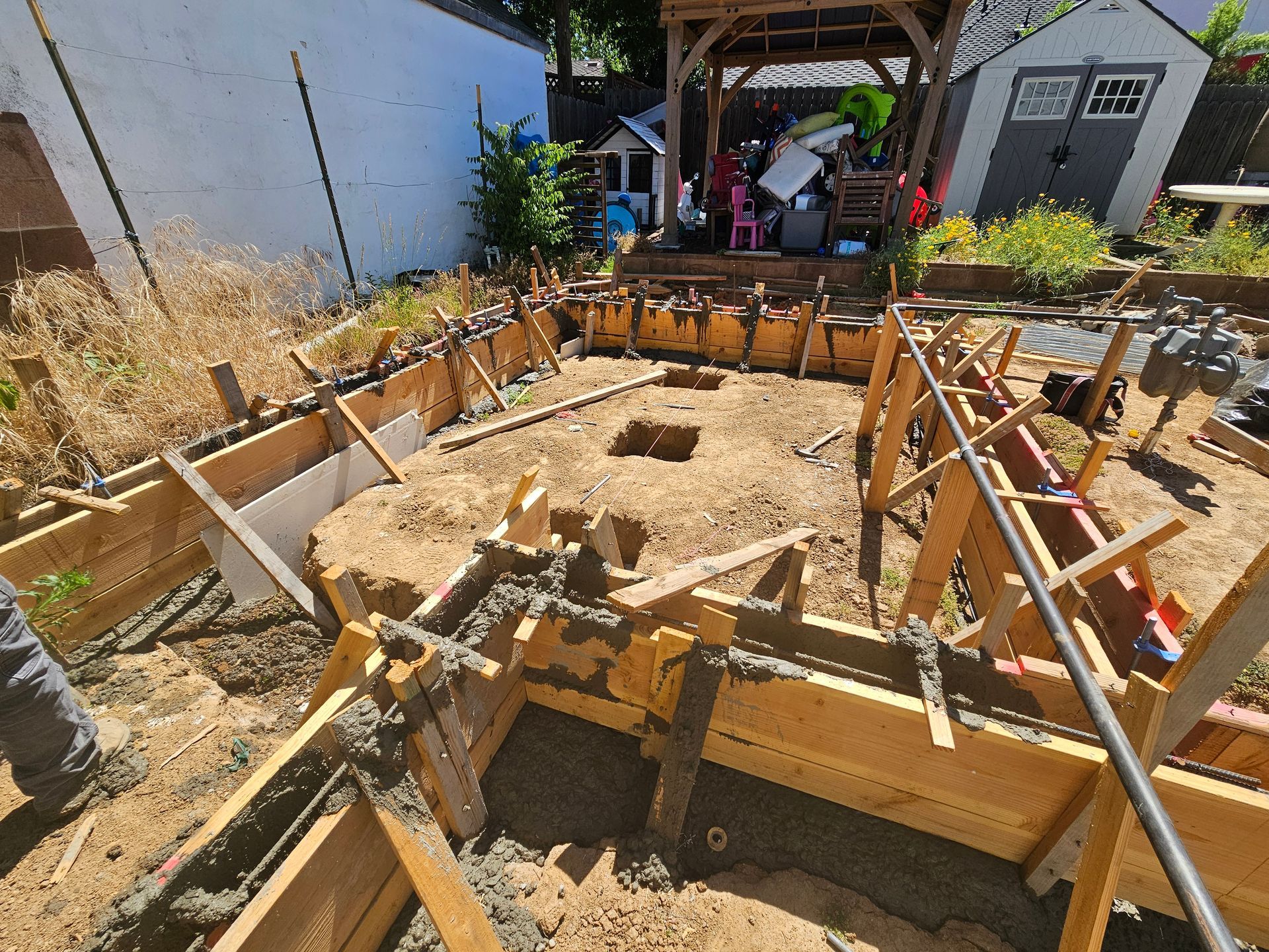 A wooden structure is being built in a backyard.