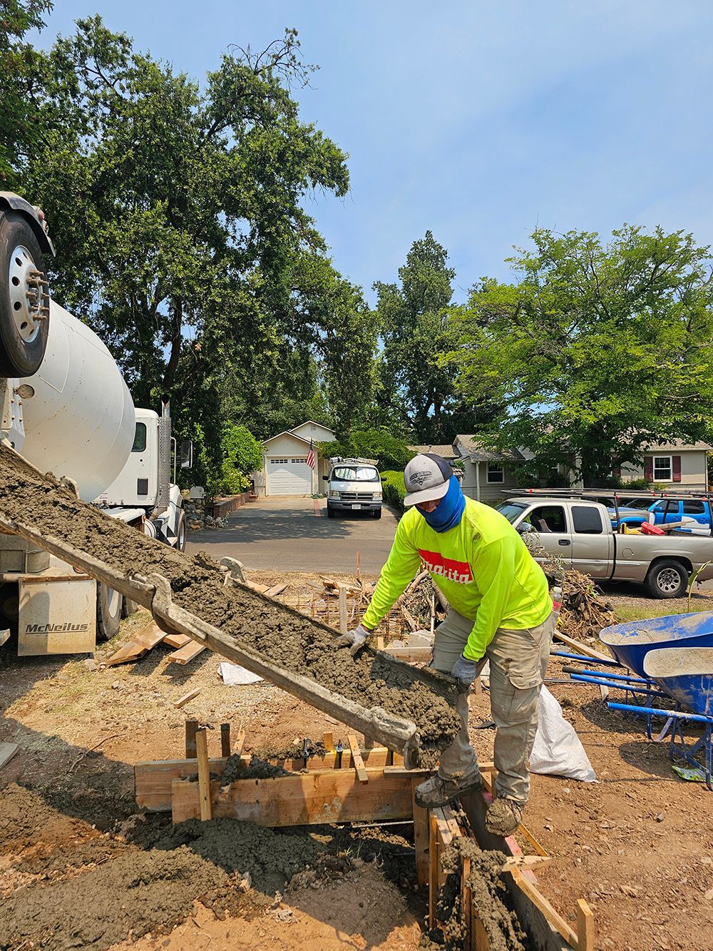 A man is standing in front of a concrete mixer truck.
