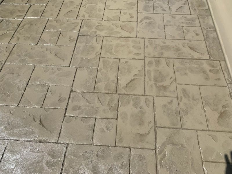 A concrete floor with a pattern of squares on it