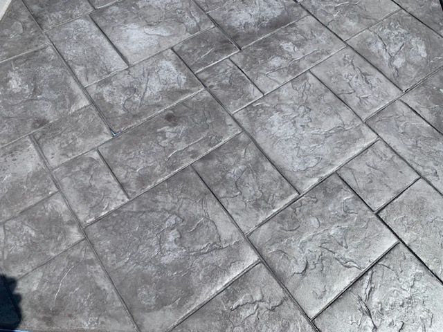 A close up of a concrete floor with a pattern of squares.