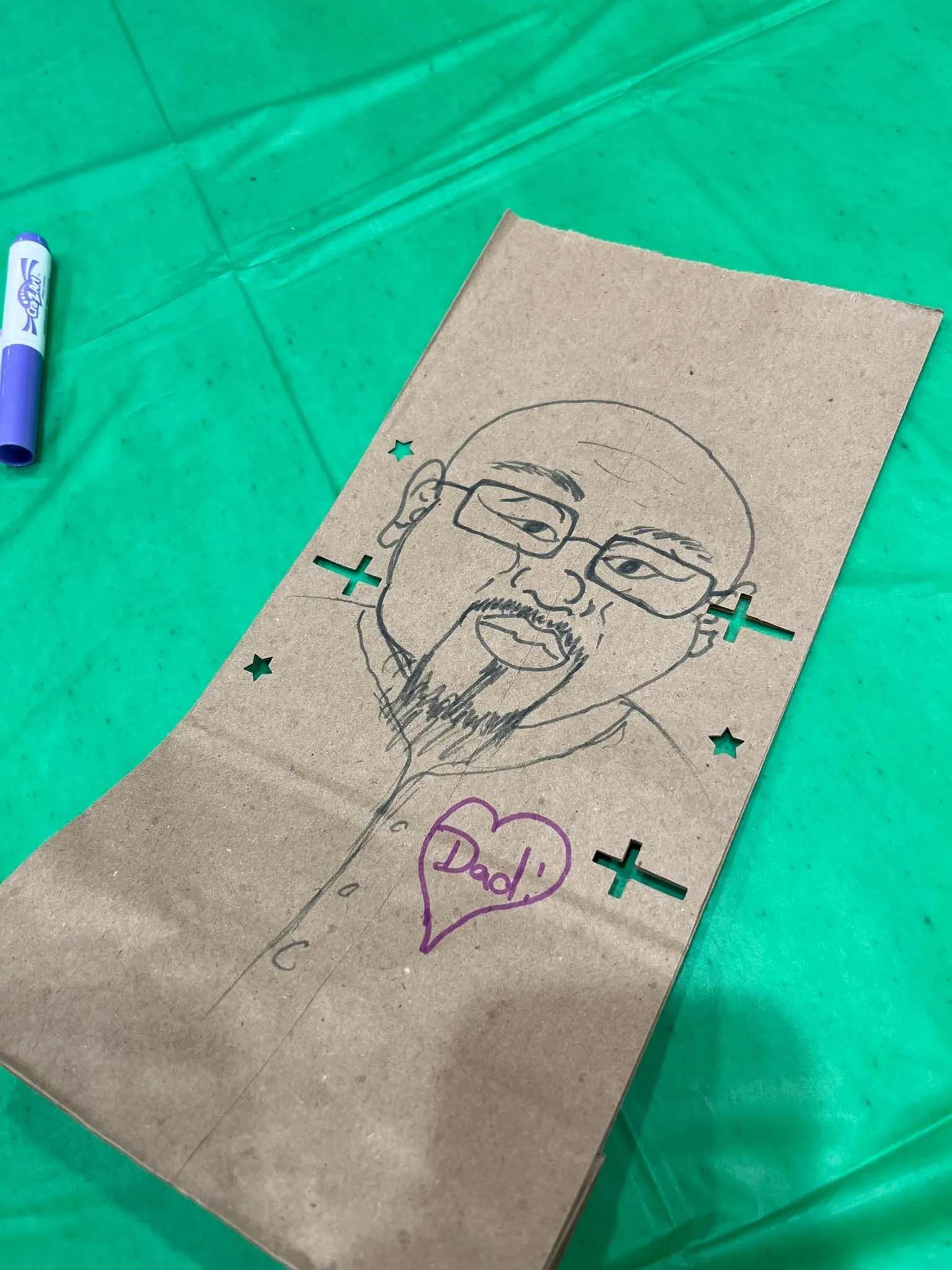 Drawing on a brown paper bag of a person with glasses and a beard, with a heart saying 