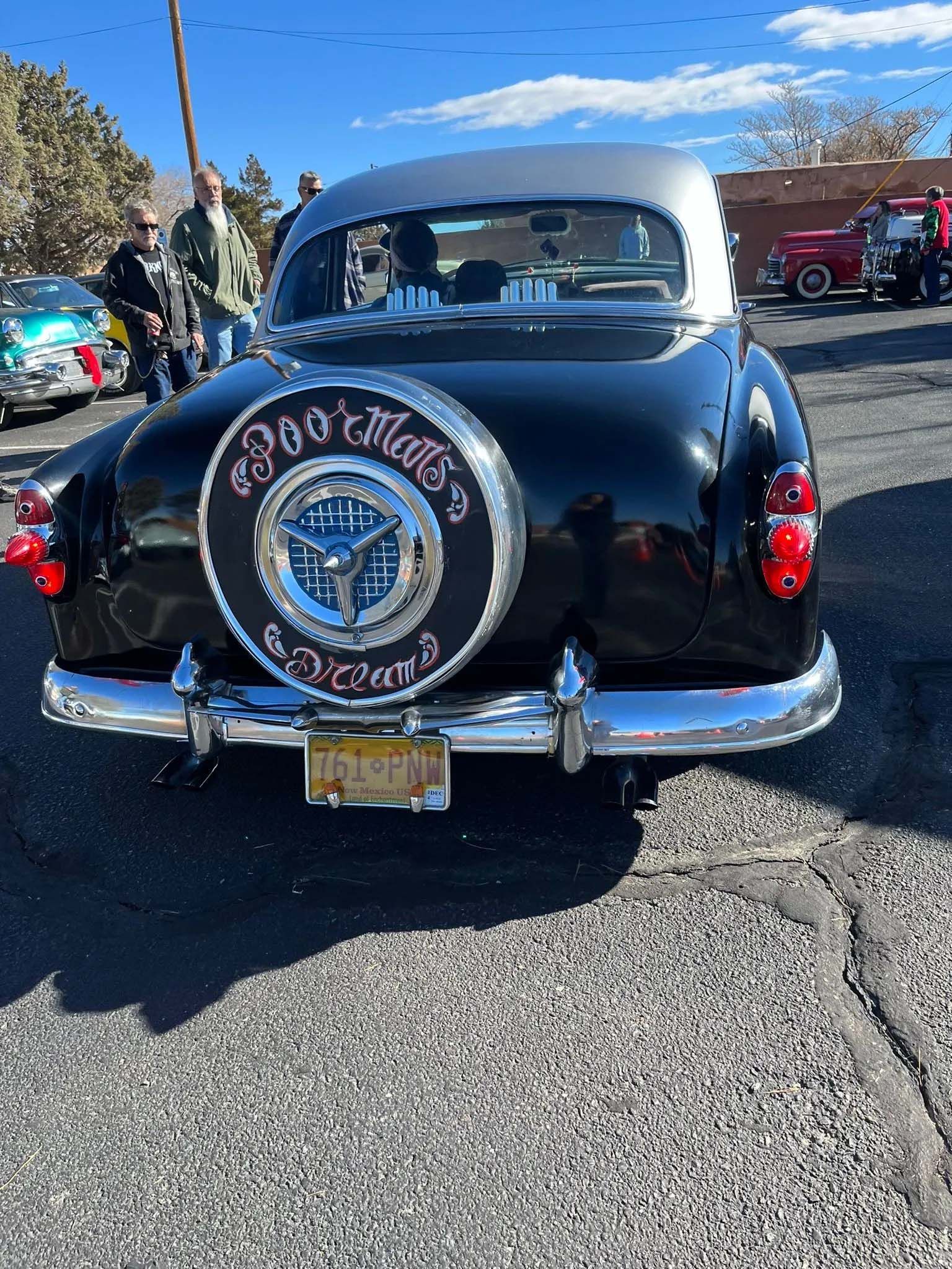 Black classic car with spare tire cover; 