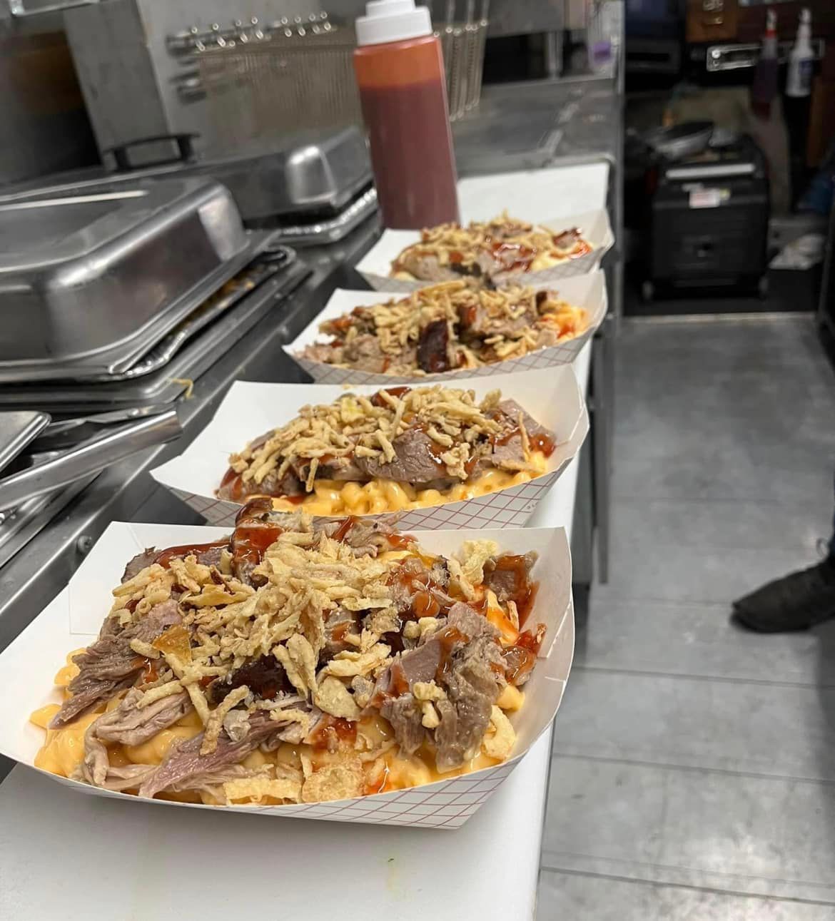 a row of trays of food are sitting on a table in a kitchen .