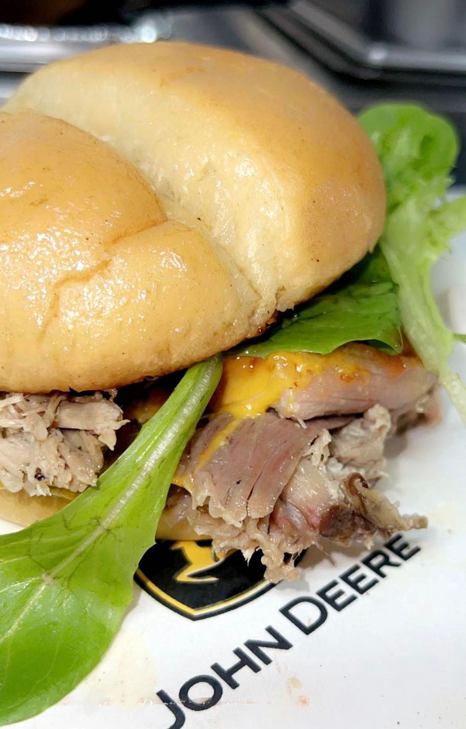a pulled pork sandwich is on a john deere plate