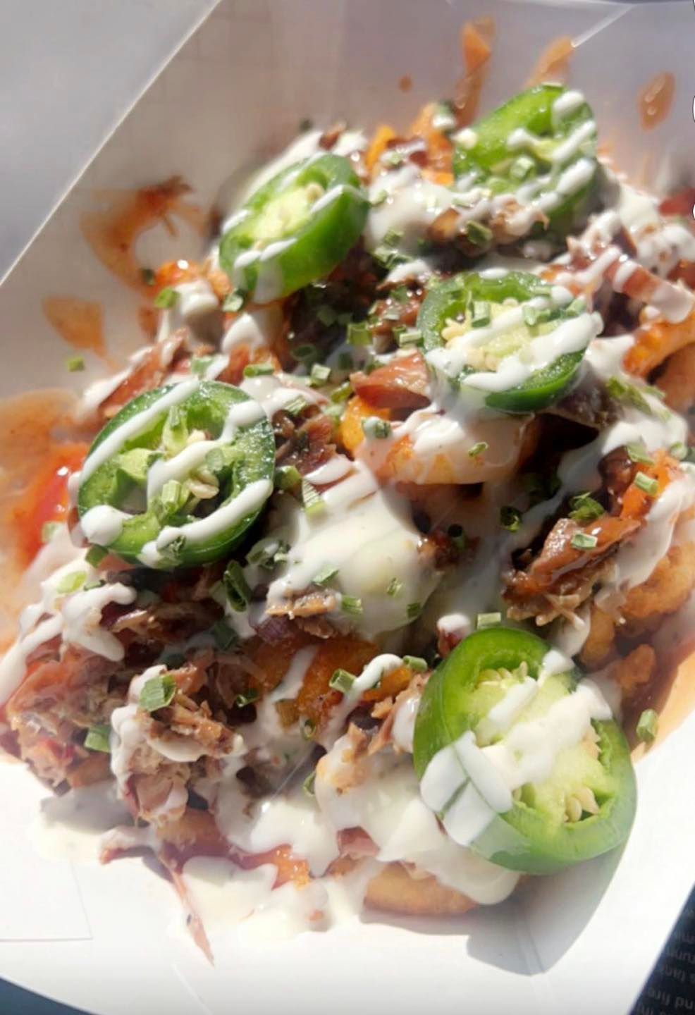 a close up of a plate of food with jalapenos and sauce