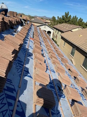 Workers installing a multi-pane skylight on a brown shingle roof. Three men, one dog. Sunny day.