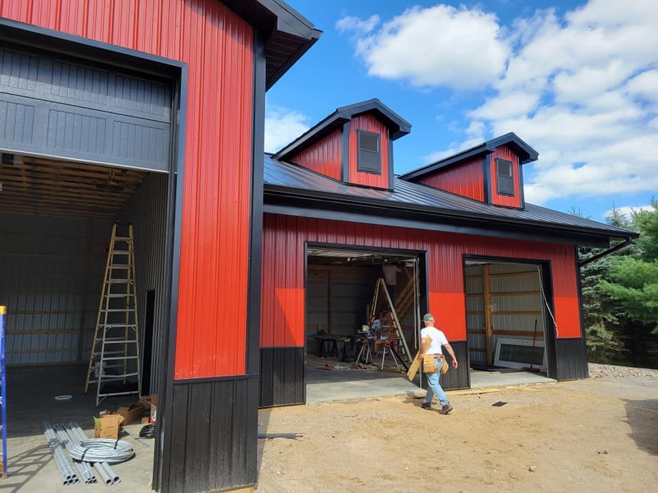 A man is standing in front of a red and black building.