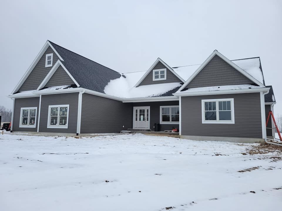 A large house with a lot of windows is covered in snow