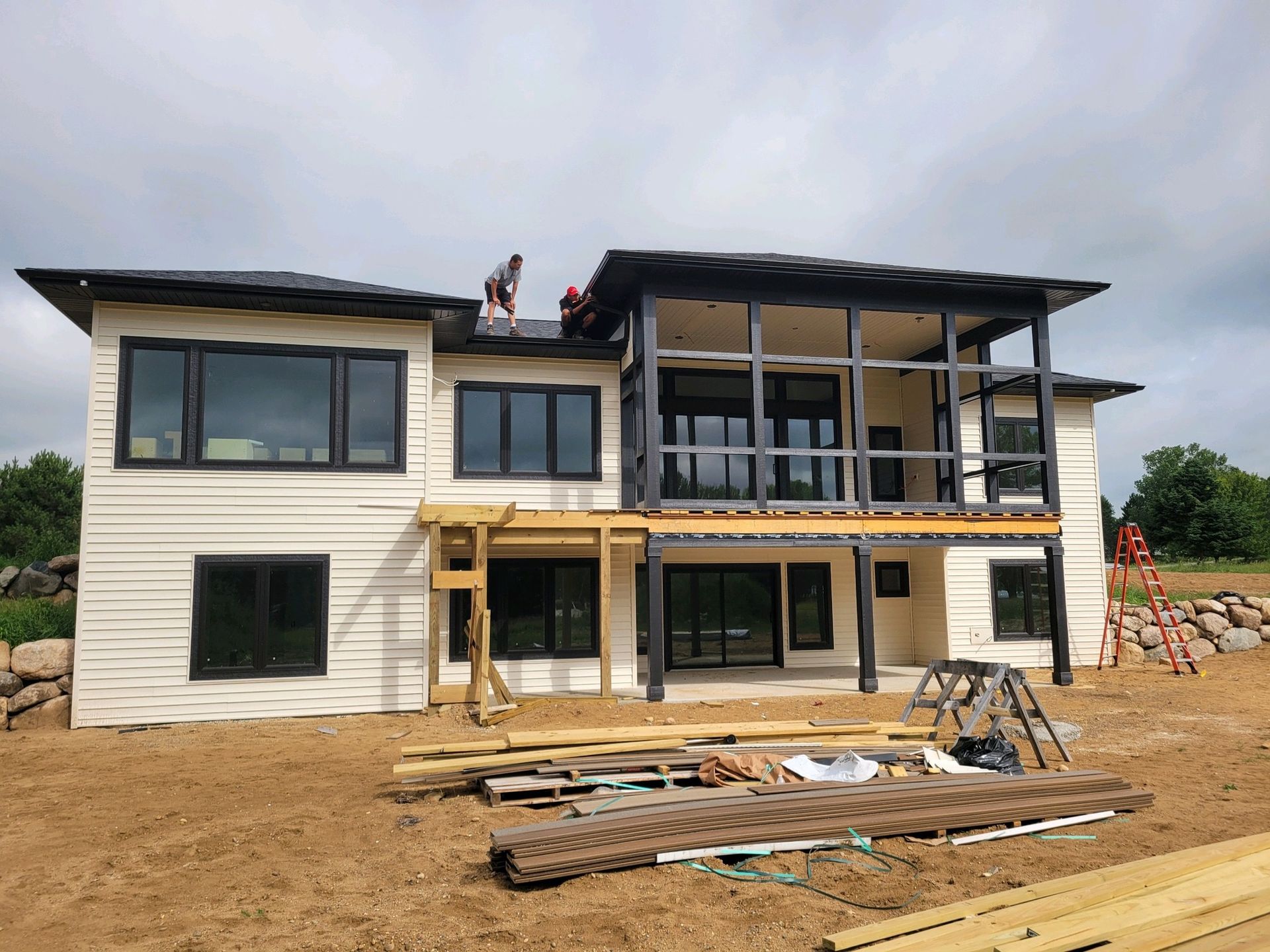 A large house is being built in a dirt field.
