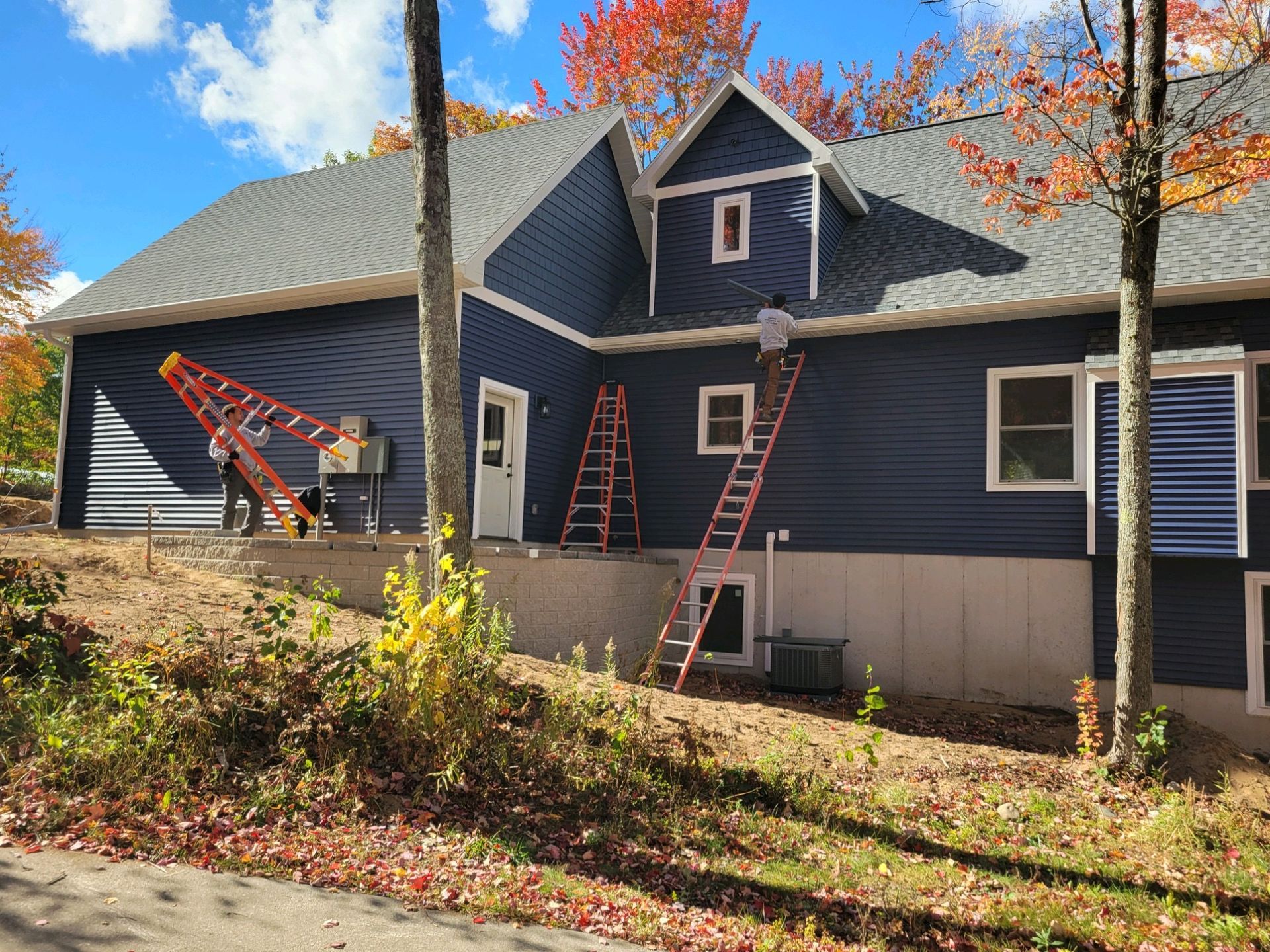 A blue house with a ladder on the side of it