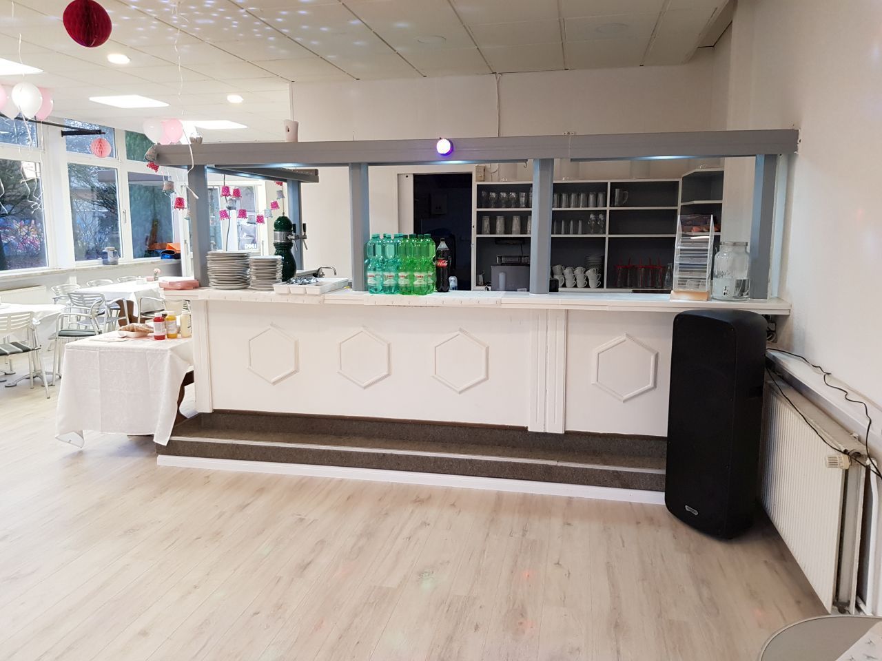 Ein großer Raum mit einer Bar und Tischen darin.