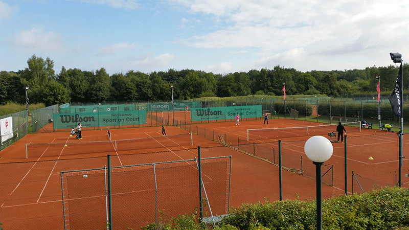 Leute spielen Tennis auf einem Wilson-Tennisplatz
