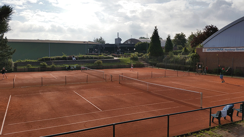 Eine Gruppe von Leuten spielt Tennis auf einem Tennisplatz.