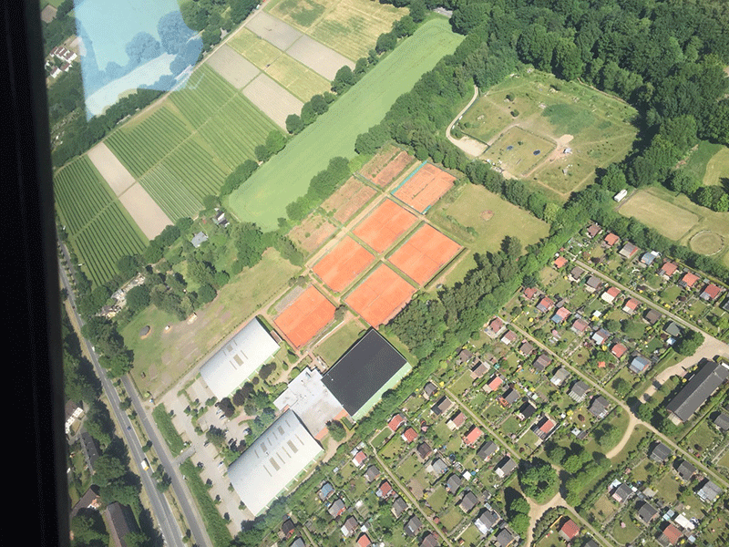 Eine Luftaufnahme eines Wohngebiets mit Tennisplätzen