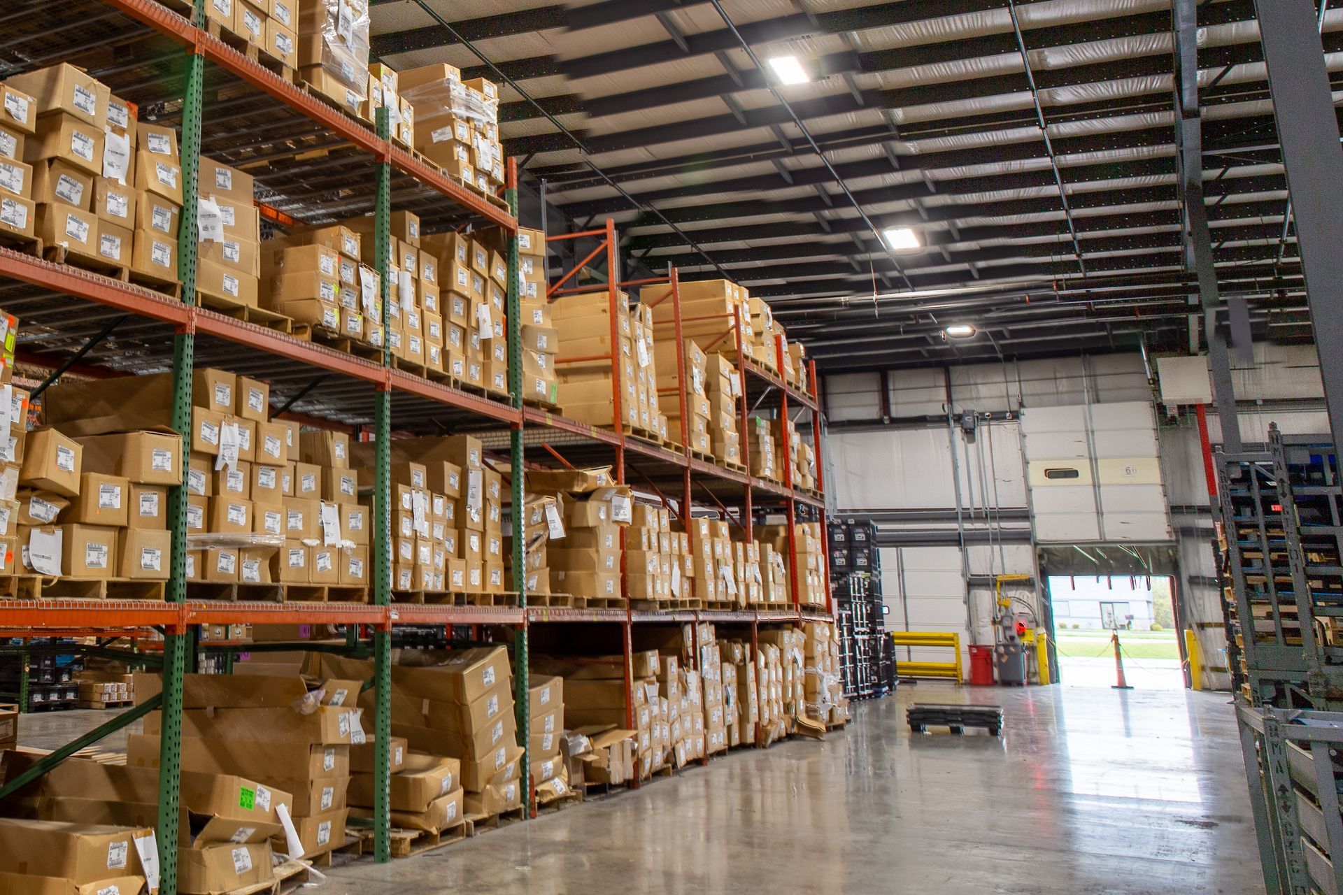Warehouse interior with shelves stacked with cardboard boxes.
