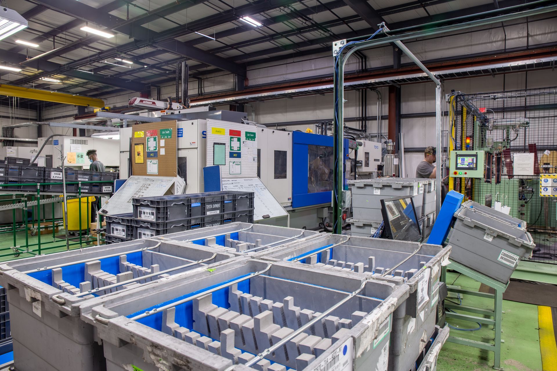 Industrial factory interior with machinery, bins, and workers.