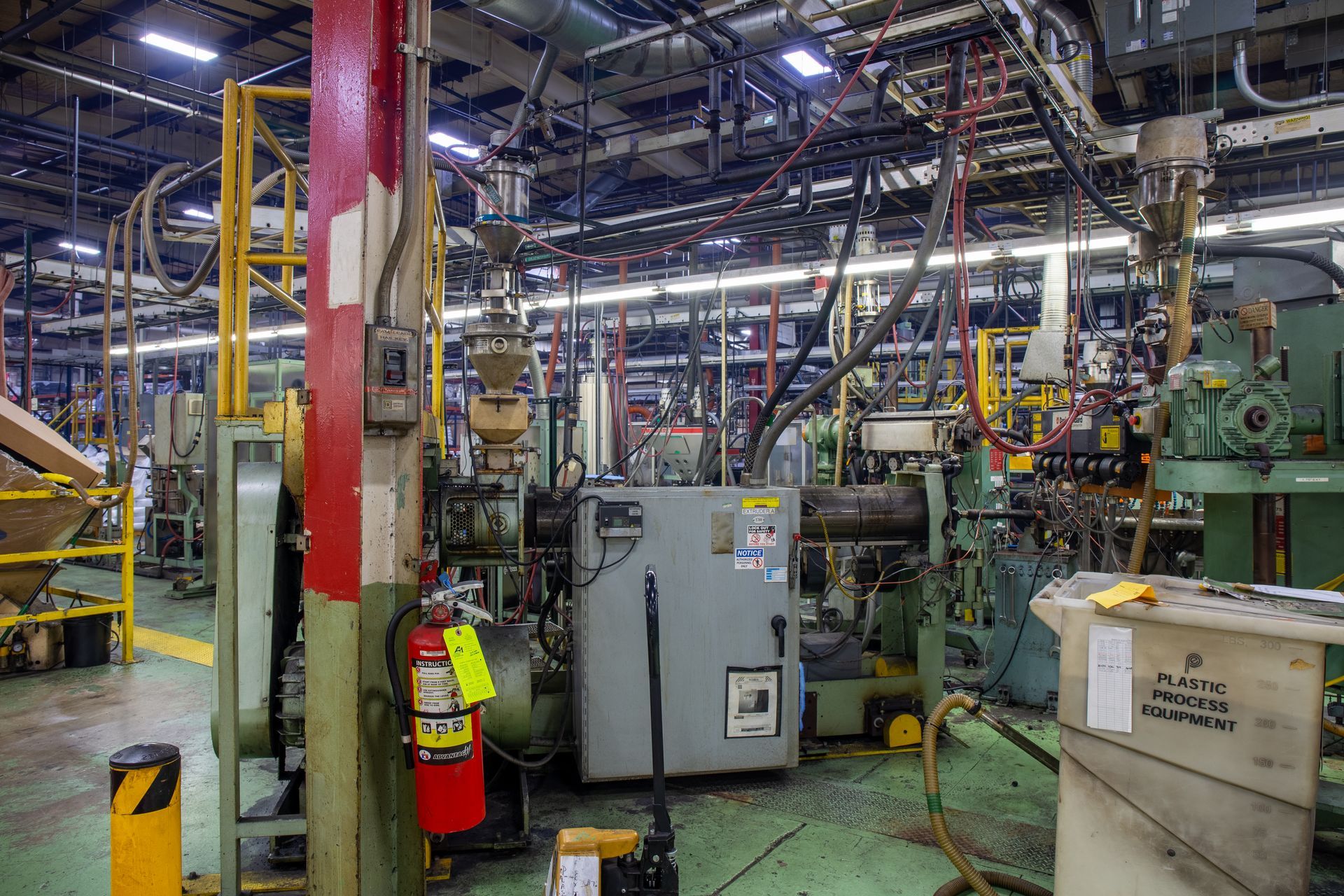 Interior of a manufacturing plant with machinery, pipes, and electrical components.