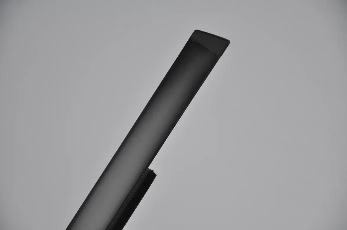 A partially visible, angled, dark tube against a light gray background.