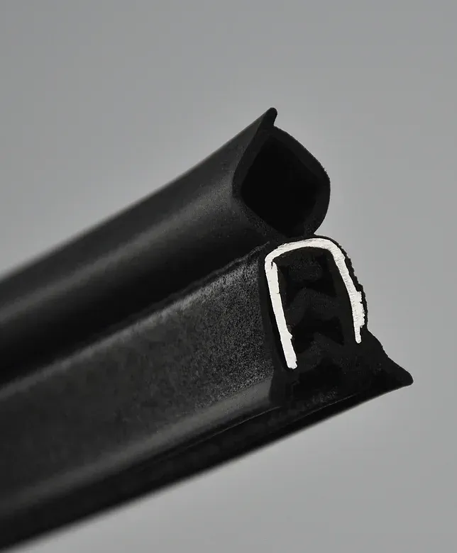 Black rubber extrusion seal with a white core, angled against a gray background.