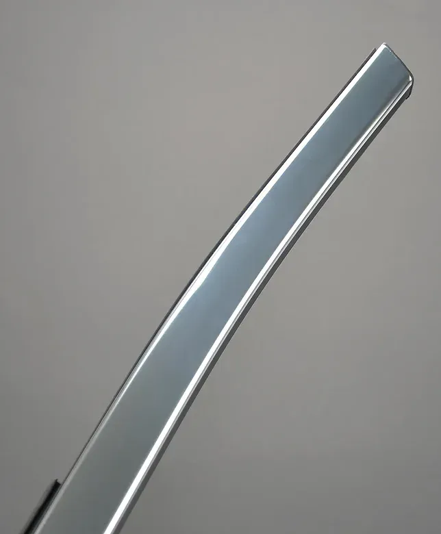 Curved, shiny, silver metal bar against a gray background.