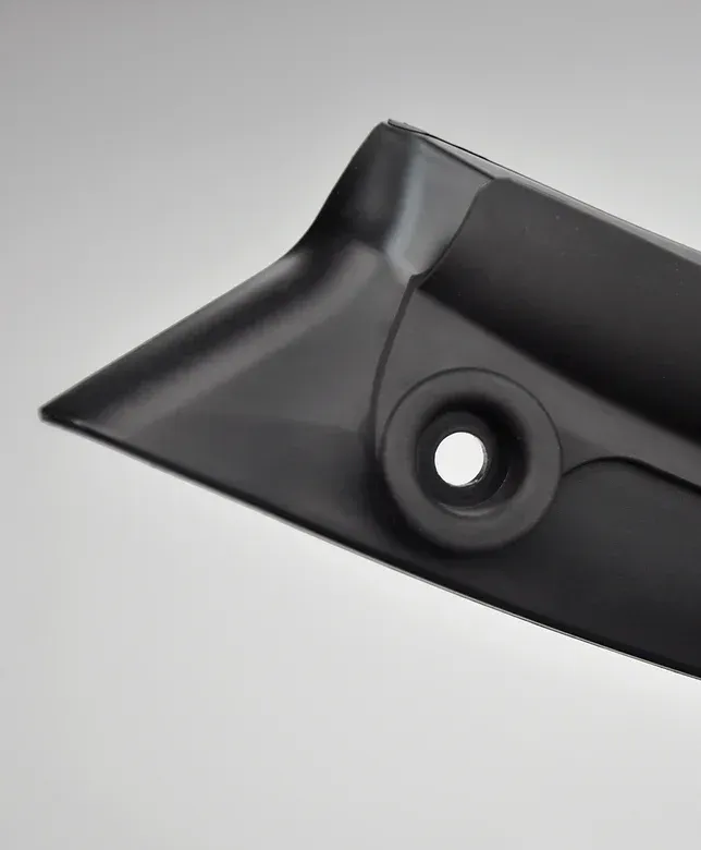Black plastic corner piece with hole and angled edge.