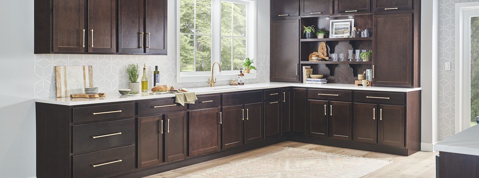 Modern kitchen with dark wood cabinets, white countertops, and a window over the sink