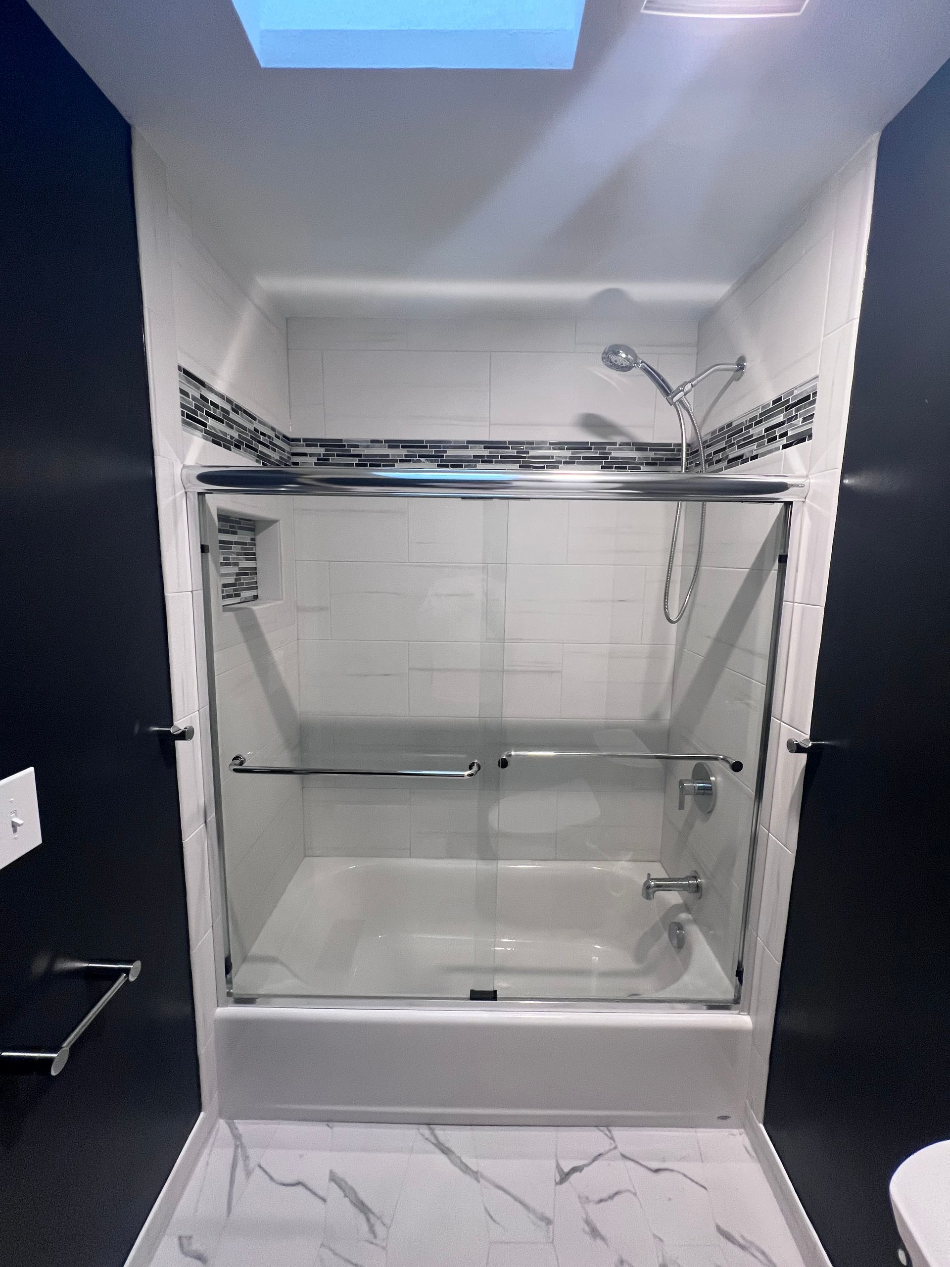 Modern bathroom vanity with white sink, mirrored cabinet, glass shelves, and marble-patterned countertop.