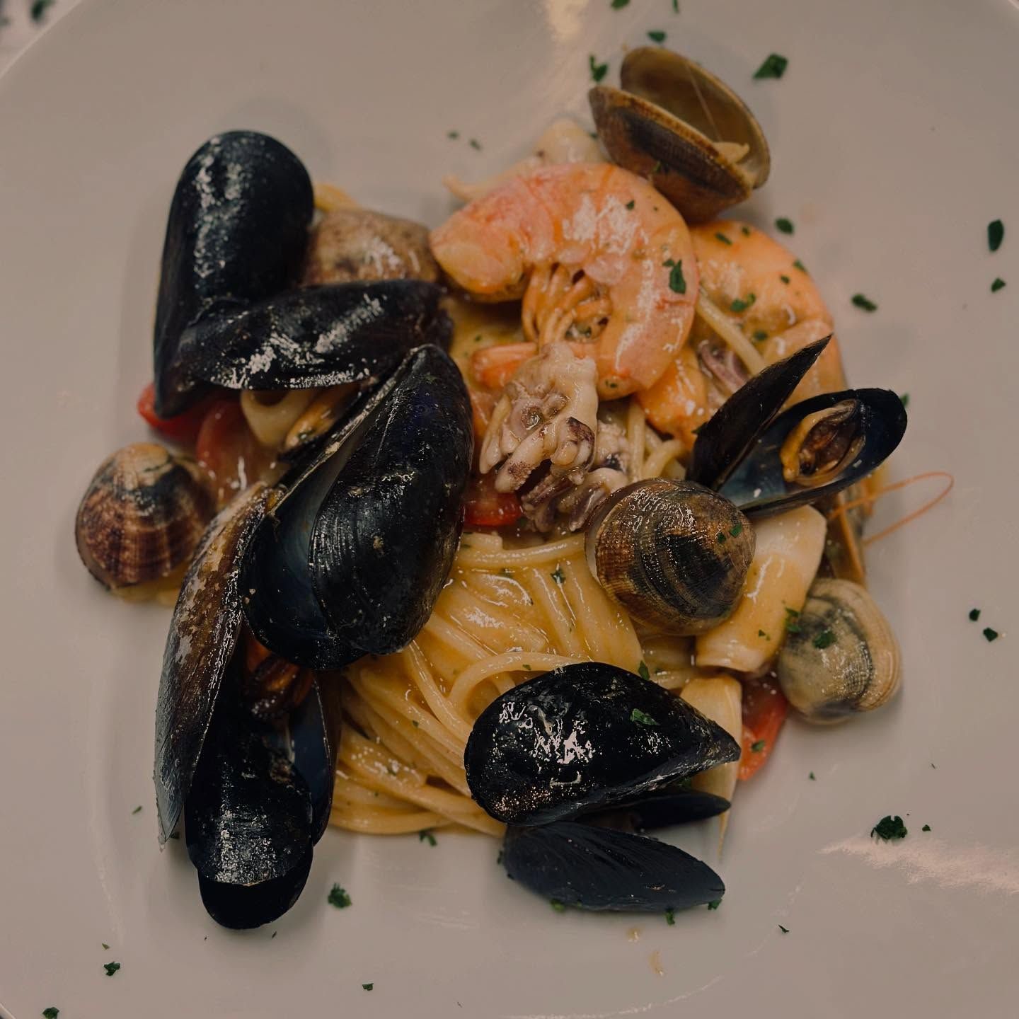 Piatto di spaghetti condito con cozze, gamberi, vongole e calamari.