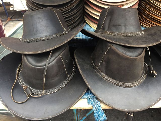 Three cowboy hats are stacked on top of each other on a table