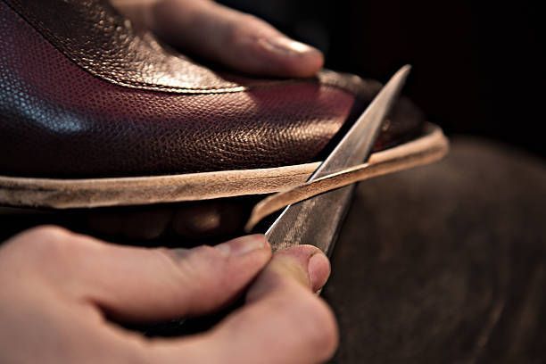 A person is cutting a shoe with scissors.