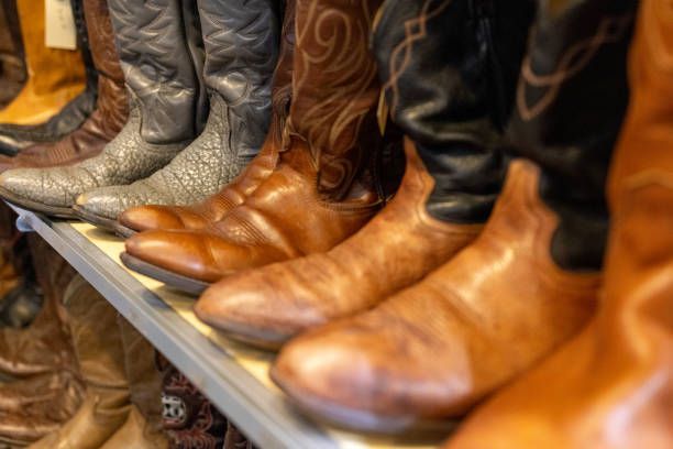 A row of cowboy boots are lined up on a shelf