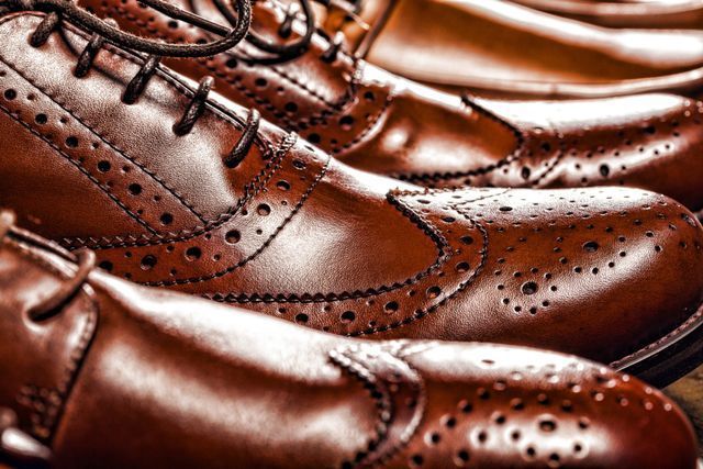 A close up of a row of brown leather shoes on a table.