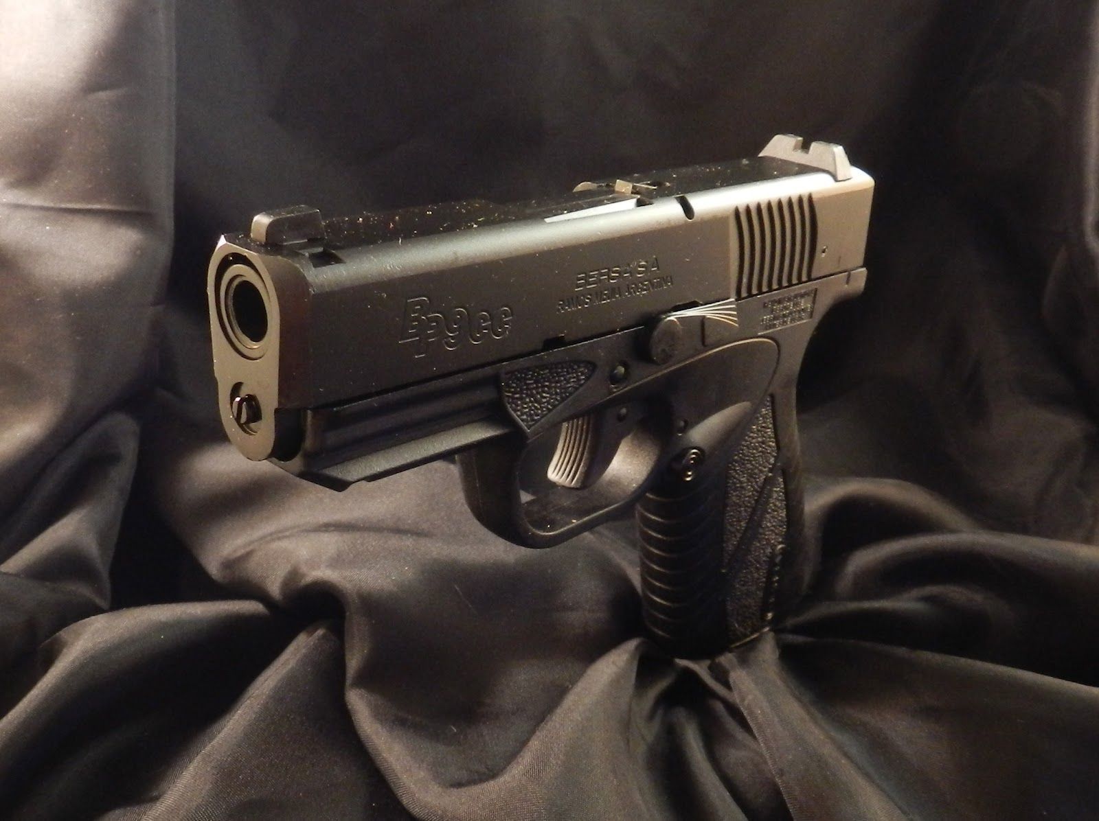 Black handgun on dark fabric.