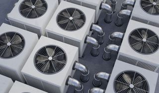 Rows of outdoor HVAC condenser units with visible fans and piping, viewed from above
