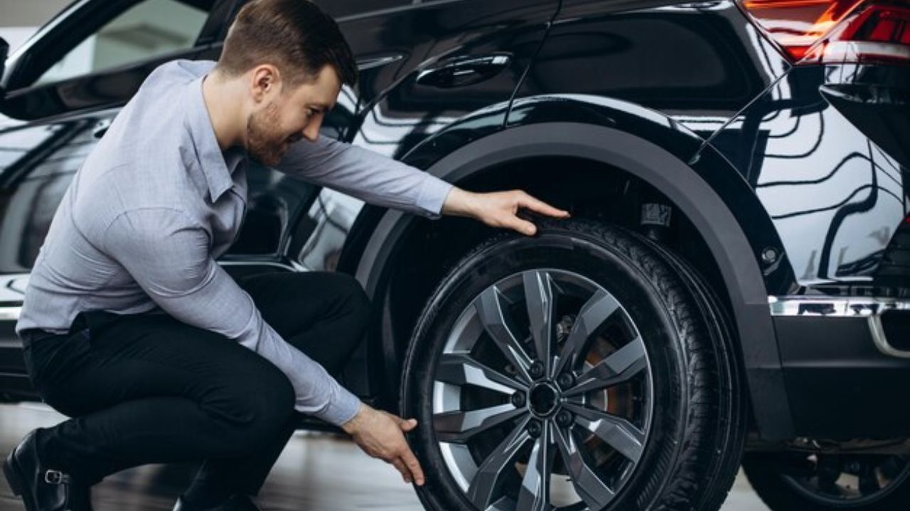 A man checking his car’s wheel alignment