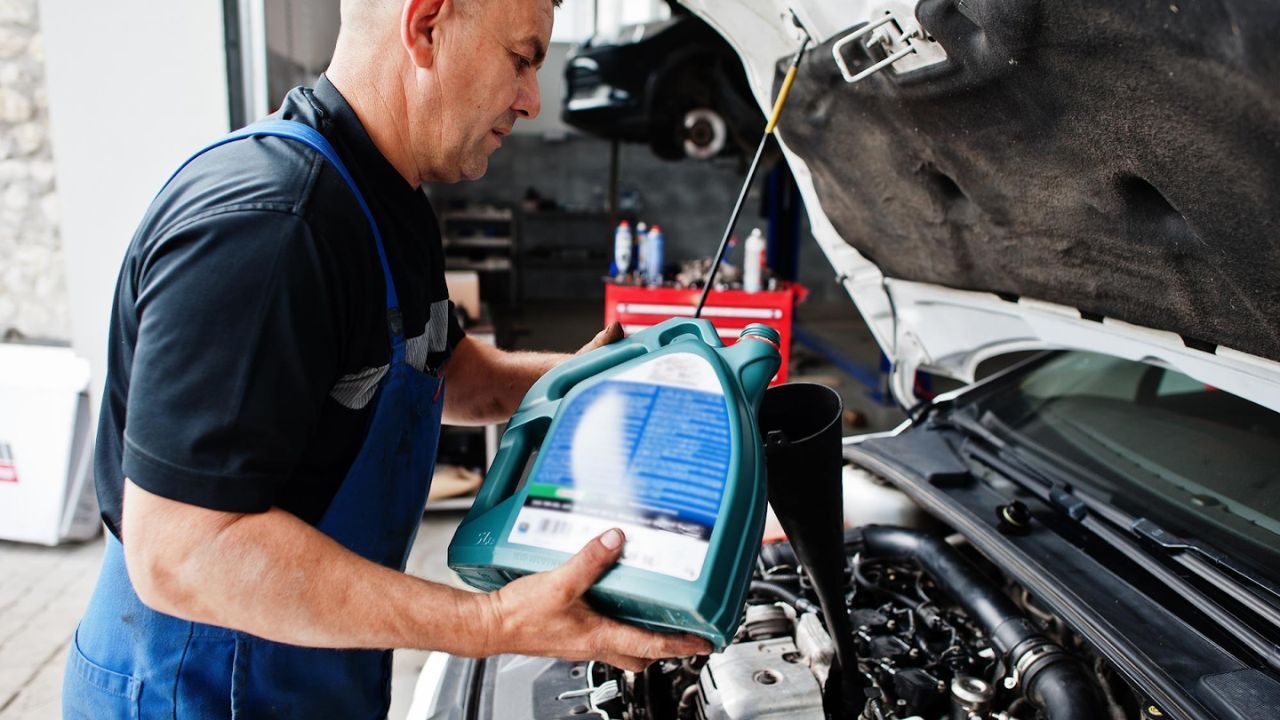 Automobile mechanic adding fresh brake fluid during a vehicle service.
