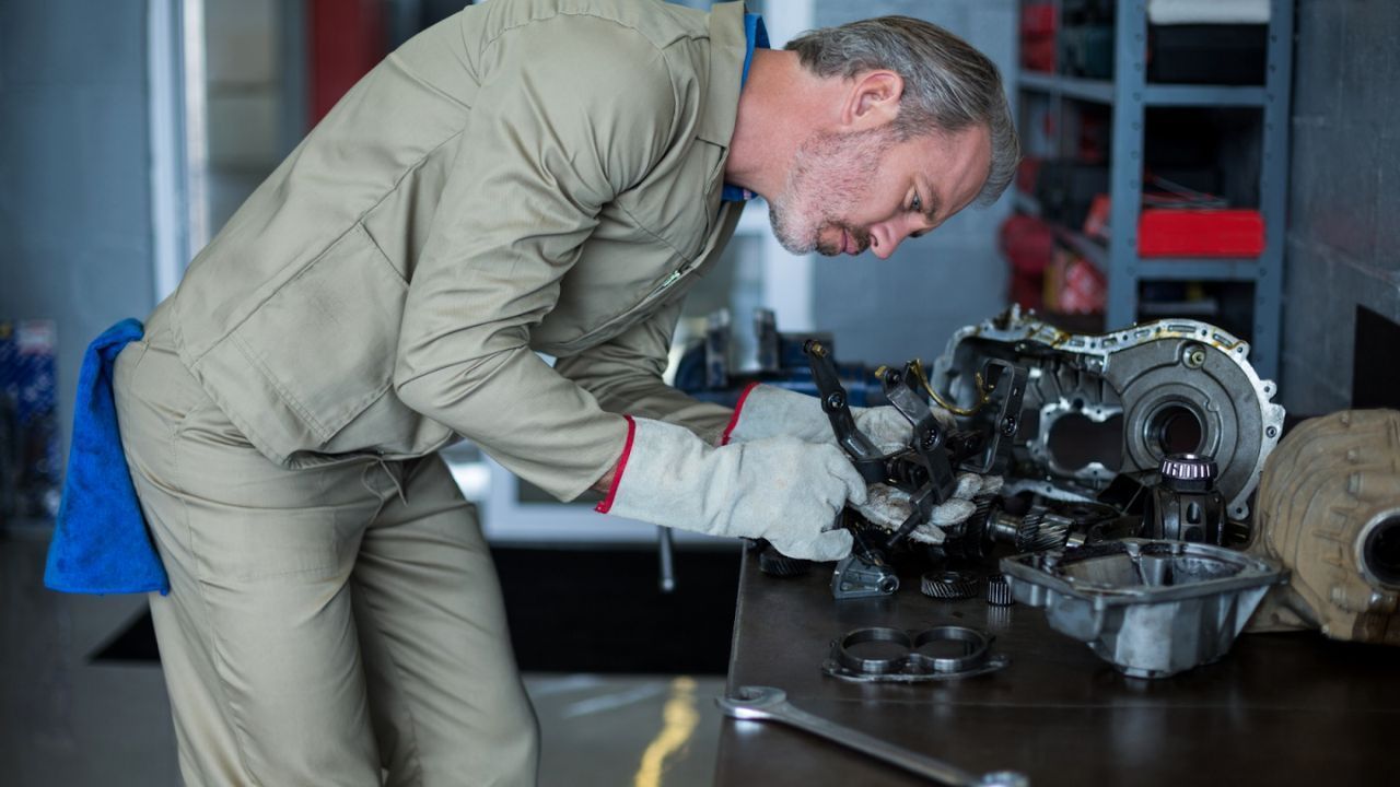 Technician working on transmission parts placed on a workbench
1. Slow or Delayed Acceleration

