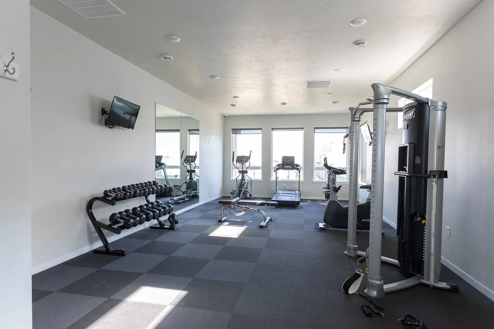 A gym with a lot of equipment and a large mirror