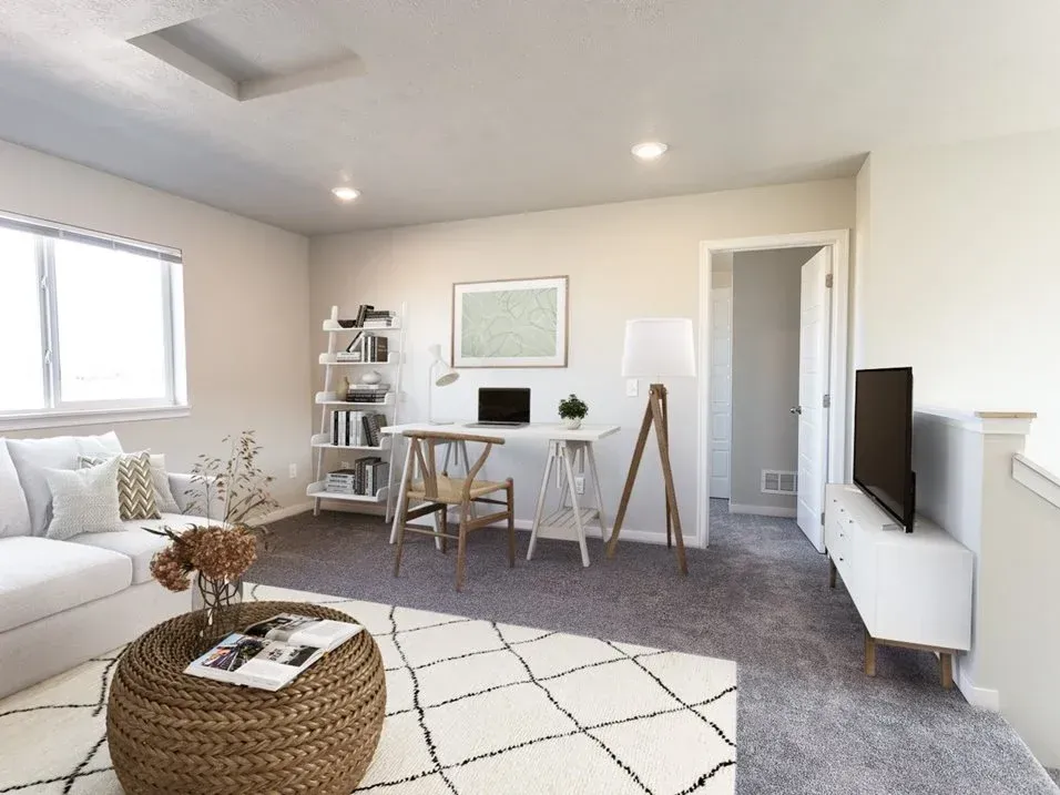 A living room with a couch , desk , and television.