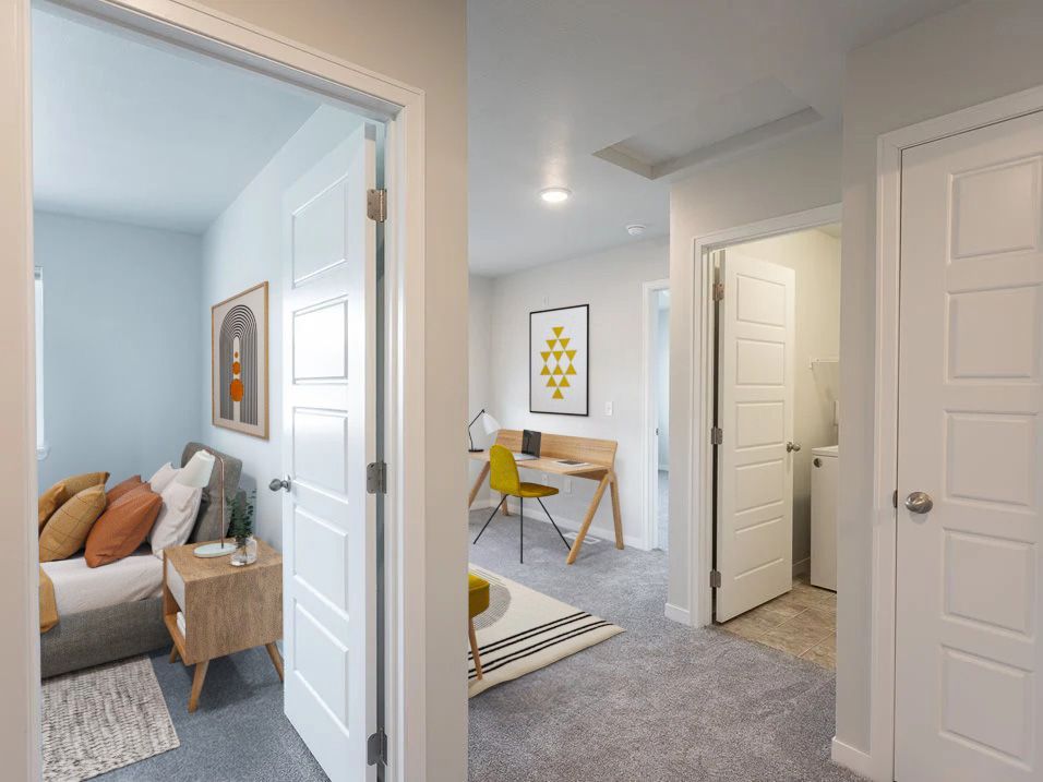 A bedroom with a bed and a desk in a house.