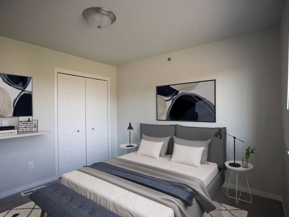 A bedroom with a large bed and a painting on the wall.