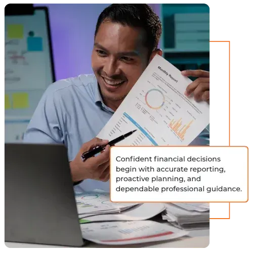 Professional reviewing financial report beside laptop, pointing to charts during meeting.