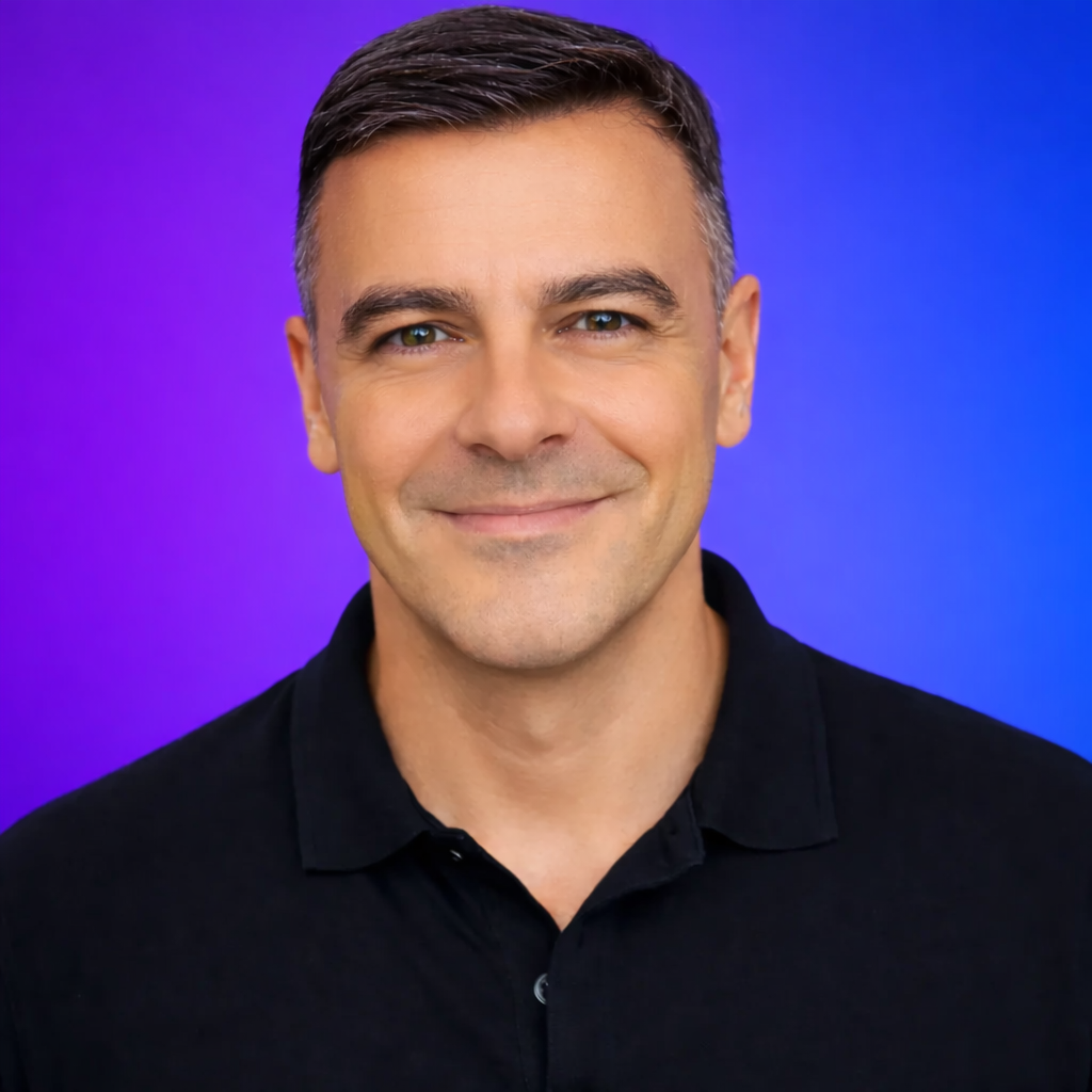 Man in black shirt smiles against a purple background.