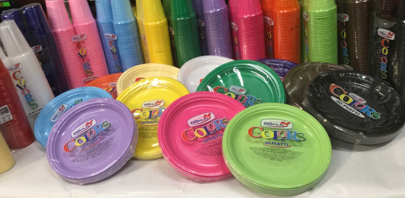 Un mucchio di piatti e bicchieri di plastica sono appoggiati su un tavolo.