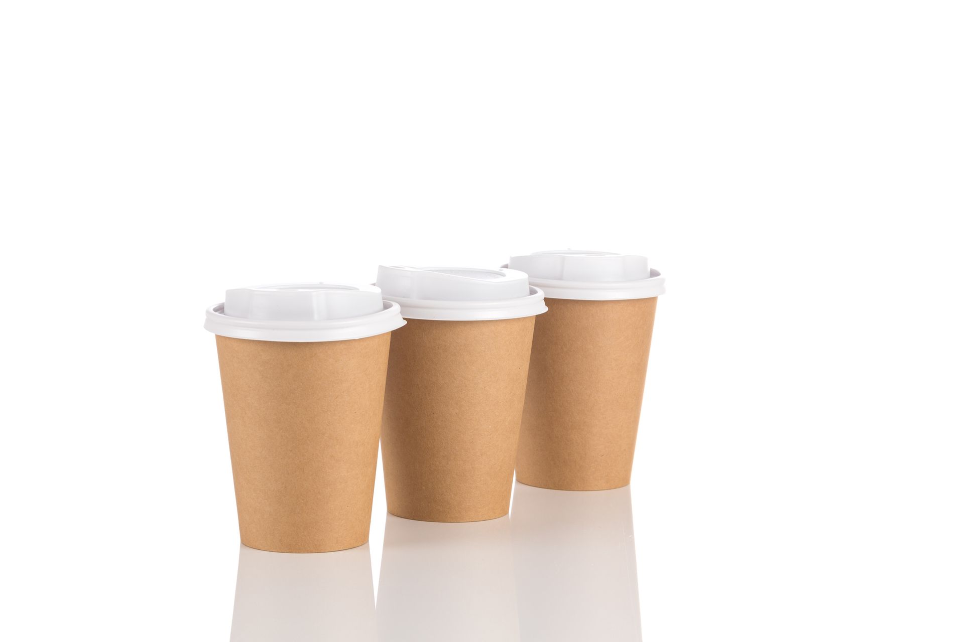 Tre tazze da caffè di carta marrone con coperchi bianchi su uno sfondo bianco.