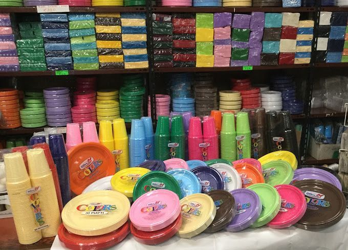 Un negozio pieno di tanti piatti e bicchieri di plastica colorati