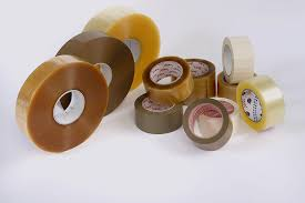 Un mucchio di rotoli di nastro adesivo sono appoggiati uno sopra l'altro su un tavolo.