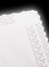 Primo piano di un tovagliolo bianco con bordo in pizzo su sfondo nero.