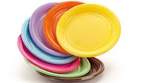 Una pila di piatti di plastica colorati su uno sfondo bianco.