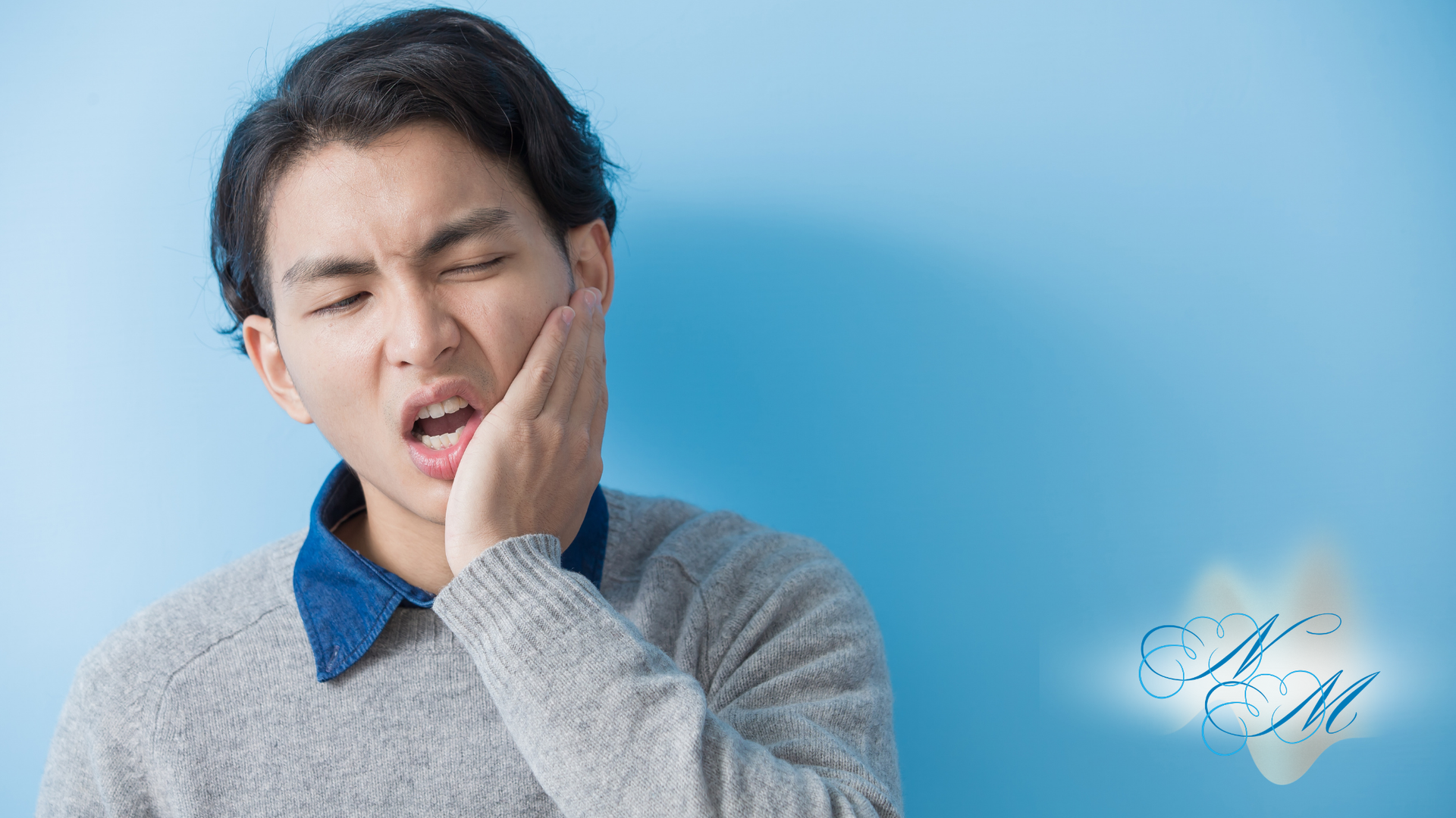 Person holding cheek with a pained expression against a blue background